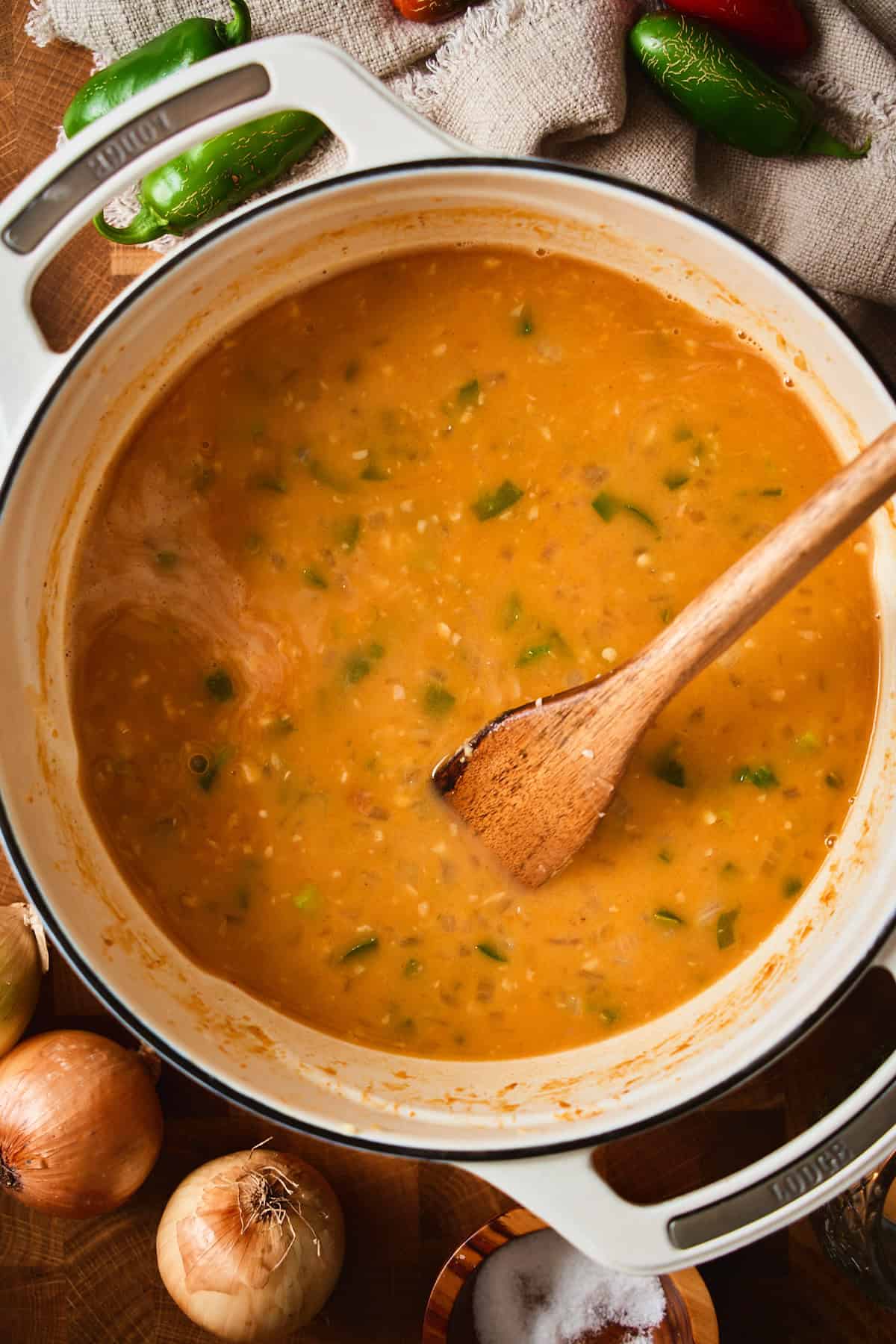 Thin, brothy jalapeño popper soup base in a Dutch oven after adding the stock.