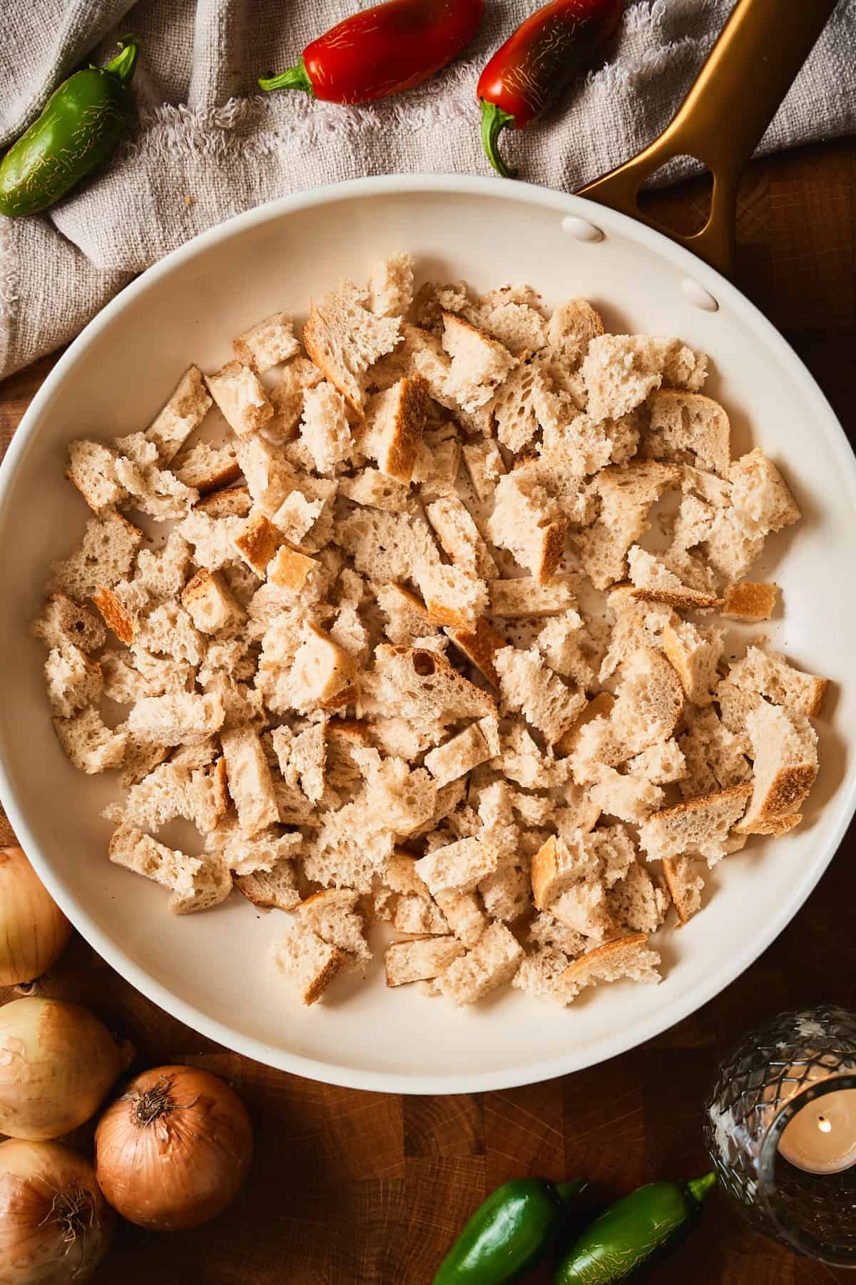 Torn pieces of sourdough bread in a skillet before toasting.