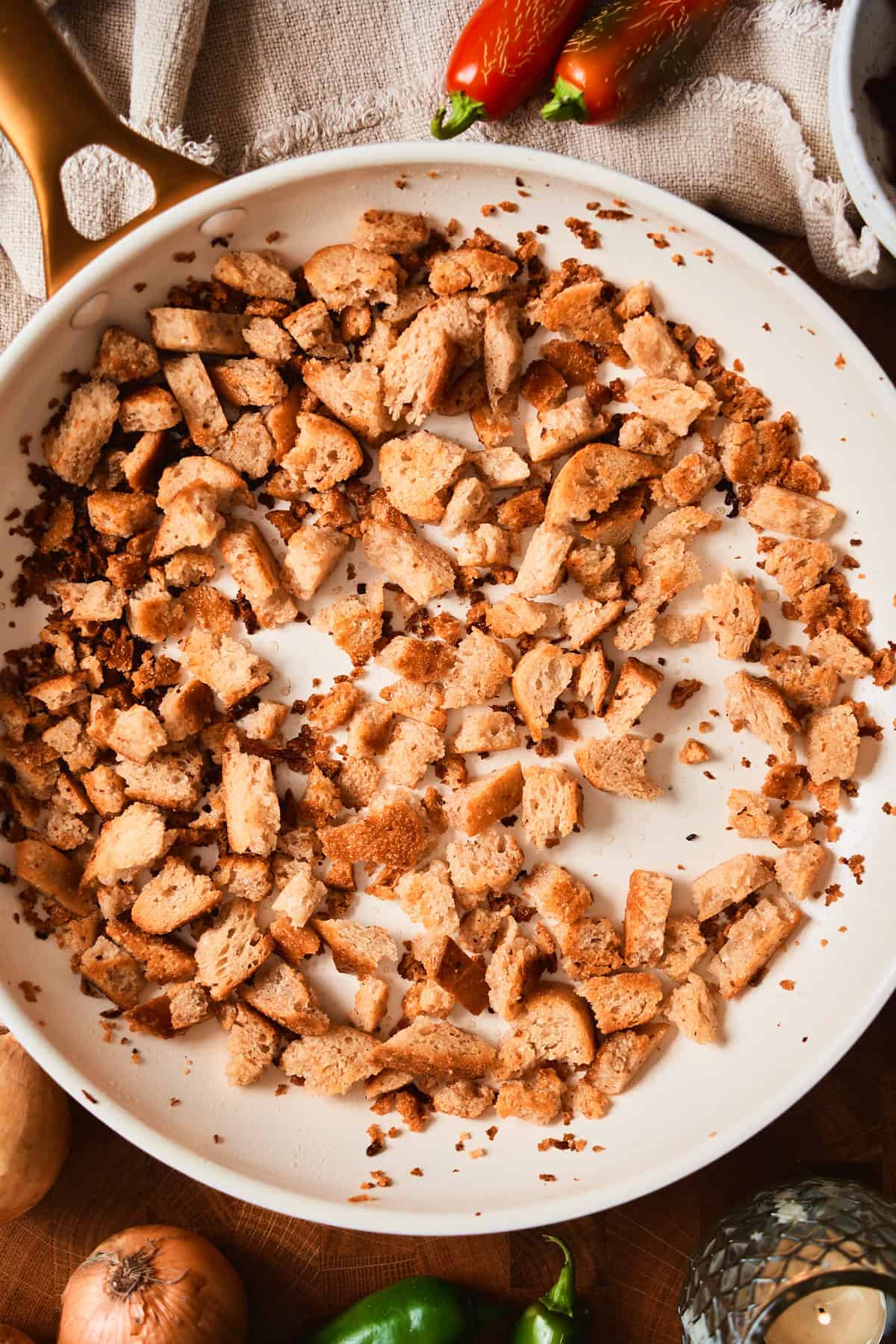 Golden toasted sourdough croutons in a white skillet.